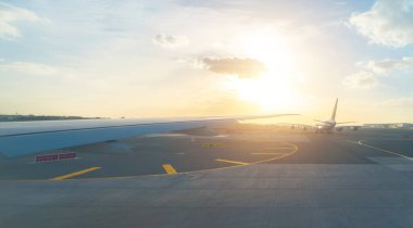 Bir uçak jetinin uçuş ve iniş kanadı, havaalanındaki pist penceresinden kentsel şehir manzaralı binalar. Seyahat ve ulaşım kavramı.