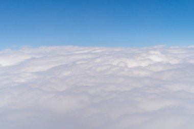 Bulutların üzerinde uçan uçak jeti seyahat ve ulaşım konseptinde pencereden mavi gökyüzü ile görünür. Doğa manzarası arka planı.