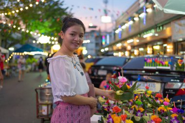 Tayland 'da Loy Krathong' la birlikte Asyalı Taylandlı bir kadının portresi. Yerel pazar festivalinde suyun üzerinde yüzüyor. Kutlama ve Kültür. İnsanlar geceleri tatil yapar. Tayland etkinliği. İnsan yaşam tarzı.
