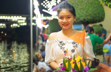 Tayland 'da Loy Krathong' la birlikte Asyalı Taylandlı bir kadının portresi. Yerel pazar festivalinde suyun üzerinde yüzüyor. Kutlama ve Kültür. İnsanlar geceleri tatil yapar. Tayland etkinliği. İnsan yaşam tarzı.