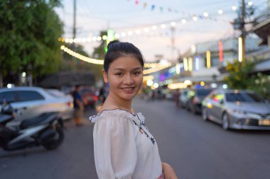 Mutlu Asyalı kadın portresi, Tayland 'ın Bangkok şehrindeki Ratchada treninde gece gezen pazar insanları, renkli çadırlar. Perakende mağazaları