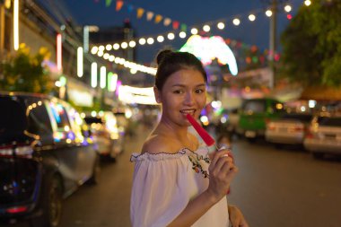 Mutlu Asyalı kadın portresi, Tayland 'ın Bangkok şehrindeki Ratchada treninde gece gezen pazar insanları, renkli çadırlar. Perakende mağazaları