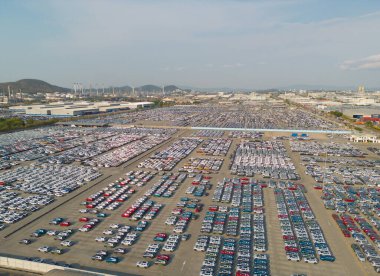 Satılık yeni arabaların park alanlarının hava manzarası stok sırası, dağıtım envanteri ithalat ve ihracat ticareti dünya çapında, otomobil ve otomobil endüstrisi lojistik küresel ulaşım dağıtımı