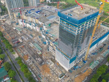 İnşaat işçileri altında vinç ve kazıcılarla çalışan yoğun endüstriyel hava manzarası. Çelik kaplı döşeme öncesi beton döşeme manzarası. Yüksek binalı mimari bina geliştirme.