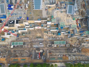 İnşaat işçileri altında vinç ve kazıcılarla çalışan yoğun endüstriyel hava manzarası. Çelik kaplı döşeme öncesi beton döşeme manzarası. Yüksek binalı mimari bina geliştirme.