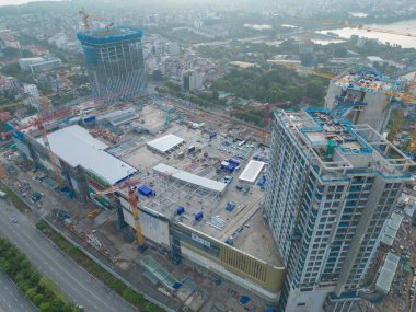 İnşaat işçileri altında vinç ve kazıcılarla çalışan yoğun endüstriyel hava manzarası. Çelik kaplı döşeme öncesi beton döşeme manzarası. Yüksek binalı mimari bina geliştirme.