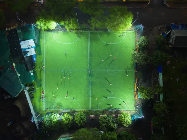 在空中俯瞰人们踢足球 体育娱乐场 国家体育馆和大学校园大楼 亚洲城市城镇 晚上的绿田 — 图库照片