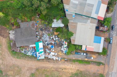 Çevre kirliliğinde endüstriyel fabrikada farklı türde çöp yığını, plastik torba ve çöp yığınlarının hava görüntüsü. Çöp boşaltma alanında atık depolama.