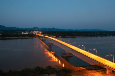 Geceleri Mekong Nehri ile Tayland Laos Köprüsü 'nün yeşil dağ tepesi manzarası. Ubon Ratchathani, Tayland 'da doğa manzarası.