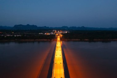 Geceleri Mekong Nehri ile Tayland Laos Köprüsü 'nün yeşil dağ tepesi manzarası. Ubon Ratchathani, Tayland 'da doğa manzarası.