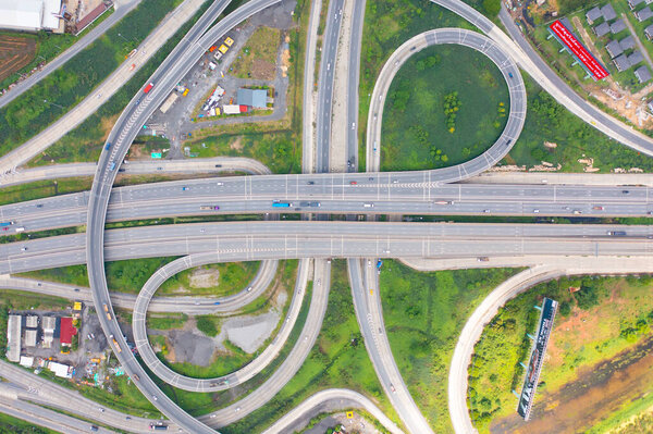 Aerial view of cars driving on highway junction or moterway. Overpass bridge street roads in connection network of architecture concept. Top view. Urban city, Bangkok, Thailand.