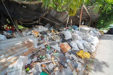 Çevre kirliliği kavramının kentsel alanındaki farklı türde çöp yığını, plastik torbalar, şişeler ve çöp bidonları içeren fabrika endüstrisi.