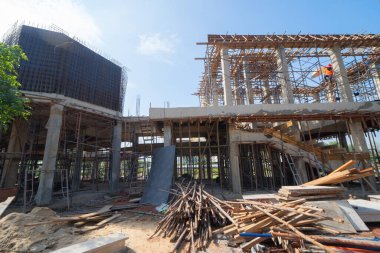 İnşaat işçileri altında vinç ve kazıcılarla çalışmakla meşgul. Çelik kaplı döşeme öncesi beton döşeme manzarası. Geliştirme mimari binası.