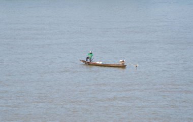 Asya 'daki doğa gölünde ya da nehirde tatlı su balığı yakalamak için ağ tutan bir balıkçı. İnsanlar.