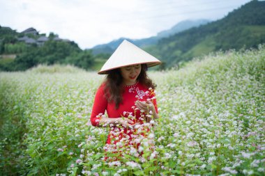 Çiçekli bir çiftçi kadın, Mu Cang Chai 'nin kırsal ya da kırsal kesimindeki yeşil tarım arazileri, Asya' daki dağ tepeleri vadisi, Vietnam. Doğa manzarası. İnsan yaşam tarzı.