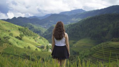 Taze çeltik pirinç terasları olan bir çiftçi kadın, Mu Cang Chai 'nin kırsal ya da kırsal kesimindeki yeşil tarım arazileri, Asya' daki dağ tepeleri vadisi, Vietnam. Doğa manzarası. İnsan yaşam tarzı.