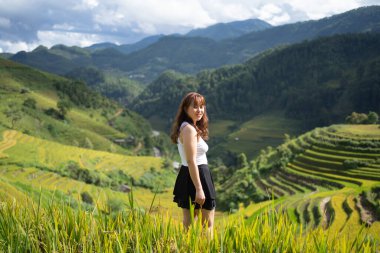 Taze çeltik pirinç terasları olan bir çiftçi kadın, Mu Cang Chai 'nin kırsal ya da kırsal kesimindeki yeşil tarım arazileri, Asya' daki dağ tepeleri vadisi, Vietnam. Doğa manzarası. İnsan yaşam tarzı.