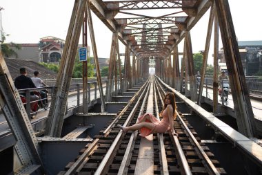 Asyalı Vietnamlı moda kadının portresi. Long Bien demiryolundaki klasik çelik tren köprüsü Hanoi, Vietnam 'daki bir nehirden geçiyor. Şehir merkezinden. İnsan yaşam tarzı.