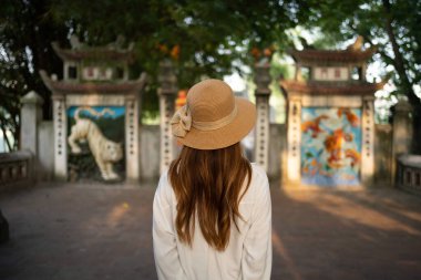 Asyalı Vietnamlı bir kadının portresi Hanoi şehir merkezindeki Hoan Kiem Gölü 'ndeki ağaçlarla halka açık park bahçesindeki Kızıl Köprü' de seyahat ediyor. Şehir, Vietnam...