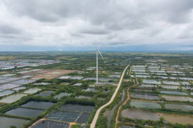 Rüzgar türbinlerinin ya da yel değirmenlerinin hava manzarası ve sanayi fabrikasındaki deniz kıyısı sahili. Su gücü, sürdürülebilir yeşil temiz enerji ve çevre kavramı. Doğa yeniliği.