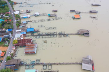 Balıkçı kentsel köy, göl ya da nehir gibi balıkçı kasabası evleriyle dolu havadan balıkçı tuzağı görüntüsü. Pak Pha, Songkhla, Tayland 'da doğa balıkçılığı ve balıkçılık aletleri. Hayvancılık çiftçiliği.