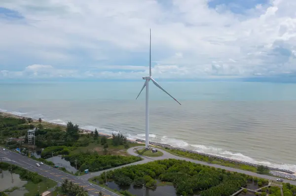 stock image Aerial view of wind turbines or windmills farm field and sea shore beach in industry factory. water power, sustainable green clean energy, and environment concept. Nature innovation.