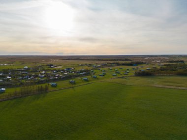 Yaz mevsiminde İzlanda adalarında dağları olan evler veya otellerin hava manzarası, Avrupa tepeleri, doğa manzarası.