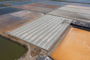 Çiftçilerin denizle birlikte deniz tuzu yığınları yapmalarını gösteren hava manzarası. Çiftlik arazisi. Tayland 'da geleneksel tuz endüstrisinde doğa malzemesi. Asya kültürü. Tarım yaşam tarzı insanları
