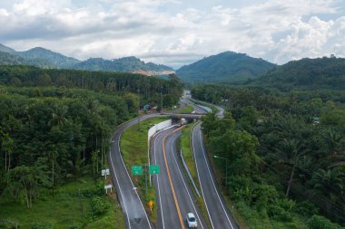 Otoyolda ya da otobanda giden arabaların hava görüntüsü. Köprü caddelerinin üst geçidi mimari konsept ağı ile bağlantılı. Orman ağaçlarının en üst manzarası. Doğa manzarası