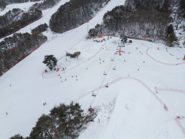 Kar dağı olan kayak merkezinin hava manzarası, kış mevsiminde spor eğlencesi..