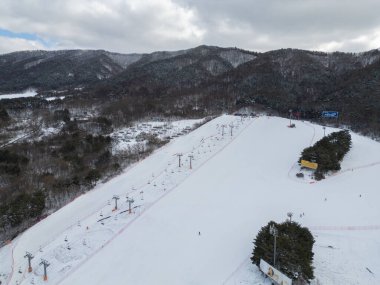 Kar dağı olan kayak merkezinin hava manzarası, kış mevsiminde spor eğlencesi..