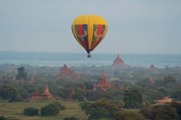 气球从缅甸巴甘市的缅甸寺庙上空飞过 是带有缅甸或缅甸森林树的世界文化遗产 旅游目的地 — 图库照片