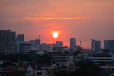 Günbatımı gökyüzü olan güneş. Soyut doğa geçmişi. Alacakaranlık vakti turuncu renkli bulutlarla dramatik mavi.