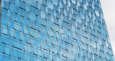 Ofis binalarının pencereleri. Şehir merkezi Dubai 'de cam mimari ön cephe tasarımı. Mavi gökyüzü ile finans bölgesinde şehir.