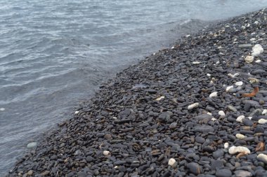 Granit çakıl taşı kayaları deniz gölü yüzeyinin döşeme dokusu. Tasarım dekorasyonu için dış malzemelerin yakın plan çekimi. Yıkım