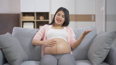 Evdeki yatak odasında mutlu Asyalı hamile bir kadının portresi. Bebek sahibi olmak. Aile hayatı işte. Aşk.