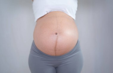 Evdeki yatak odasında mutlu hamile bir kadının portresini kapat. Bebek sahibi olmak. Aile hayatı işte. Annen seni seviyor.