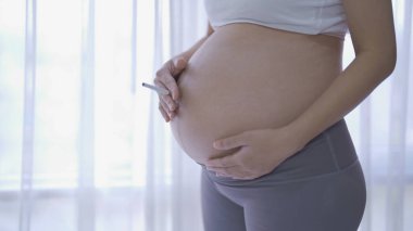 Sigara içen Asyalı hamile bir kadının portresi. Bebek sahibi olmak. Aile hayatı işte. Annen seni seviyor.