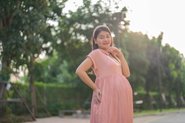 Mutlu Asyalı hamile kadın portresi halka açık bahçe parkında tatilde yürüyor. Anne sevgisi. Bebek sahibi olmak. Aile hayatı..