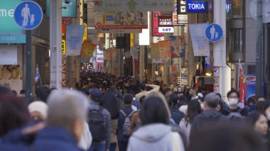 Bir grup insan, Japonya 'nın Osaka İlçesi' nde, şehir merkezindeki cadde üzerinde, zebra kavşağında ya da alışveriş merkezinde yaya geçidinde yürüyor..