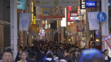 Bir grup insan, Japonya 'nın Osaka İlçesi' nde, şehir merkezindeki cadde üzerinde, zebra kavşağında ya da alışveriş merkezinde yaya geçidinde yürüyor..