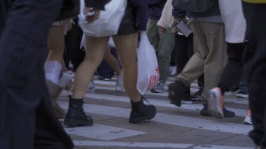 Bir grup insan, Japonya 'nın Osaka İlçesi' nde, şehir merkezindeki cadde üzerinde, zebra kavşağında ya da alışveriş merkezinde yaya geçidinde yürüyor..