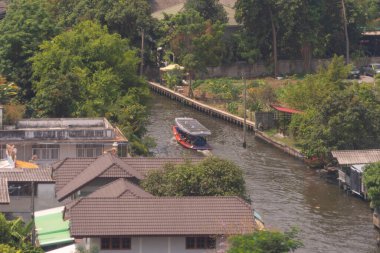 Deniz ve ağaç ormanlarının çatısında güneş pili olan yerel ahşap bir tekneye binmek. Doğa çevre manzarası arka planı.