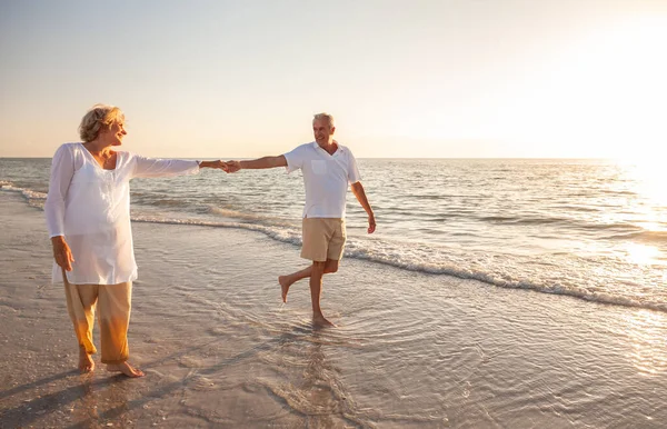 Glückliches Rentnerehepaar Das Bei Sonnenuntergang Strand Spazieren Geht Und Händchen — Stockfoto