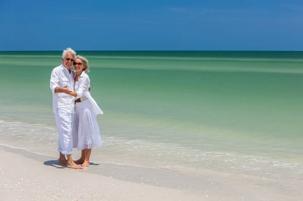 快乐高级的男人和女人夫妻跳舞和手牵上空寂的热带海滩与明亮清澈的蓝天 — 图库照片
