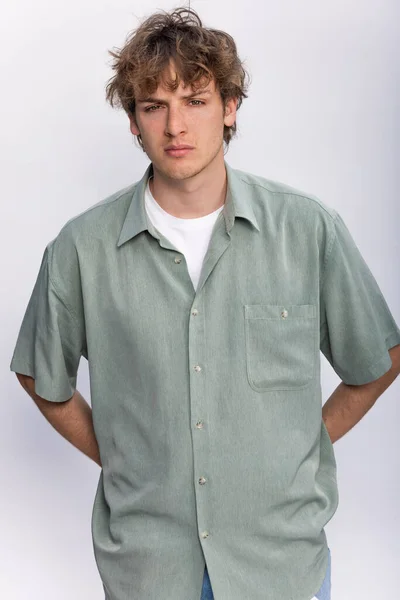 一名年轻帅气的年轻男青年身穿白色T恤衫和绿色衬衫的年轻成年男子的白色背景肖像 — 图库照片