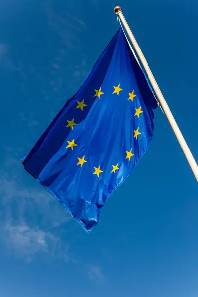 The European Flag on a flag pole against a blue sky