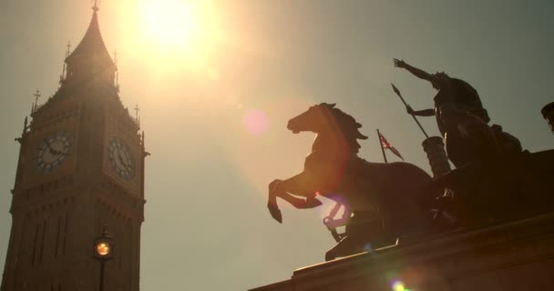 ビッグベン 議会とユニオンジャックフラッグの家 ボイデシアまたはブーディカの彫像の上を飛ぶ ウェストミンスター橋の日没で ロンドン イングランド — ストック動画