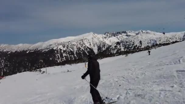 Mężczyzna Narciarz Ubrany Czarno Mężczyzna Zjeżdżający Śnieżnej Górskiej Trasie Zjazdowej — Wideo stockowe