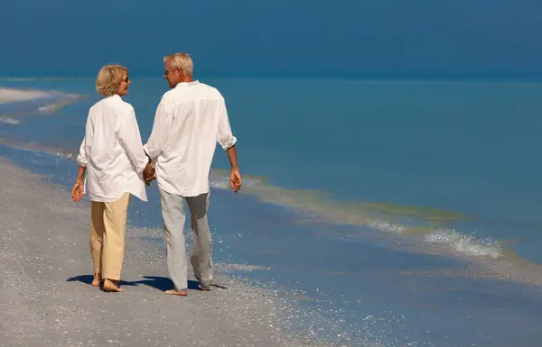 Glückliche Ältere Männer Und Frauen Spazieren Lächelnd Händchen Haltend Urlaub lizenzfreie Stockfotos